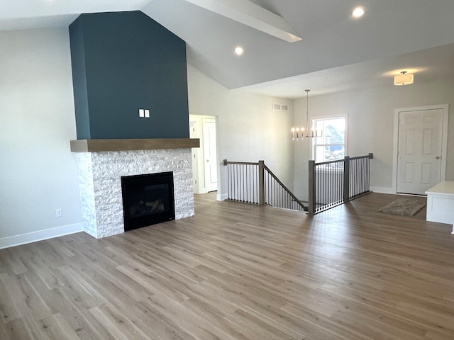 unfurnished living room featuring a chandelier, visible vents, light wood-type flooring, and baseboards