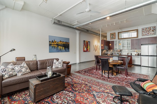 living room with ceiling fan and concrete floors