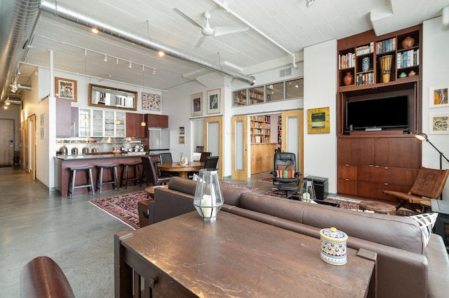 living room featuring concrete flooring and ceiling fan