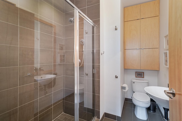 bathroom with tile patterned flooring, a shower with shower door, and toilet