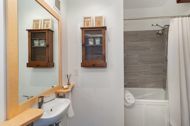 bathroom featuring sink and shower / bath combination with curtain