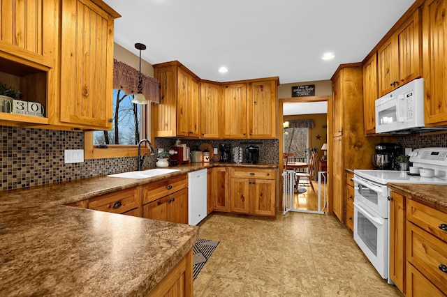 kitchen with tasteful backsplash, sink, hanging light fixtures, and white appliances