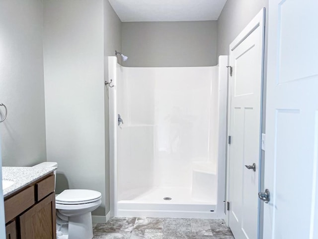 bathroom featuring walk in shower, vanity, and toilet