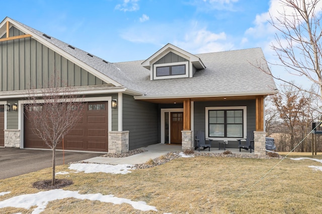 craftsman inspired home with a front lawn, a porch, and a garage