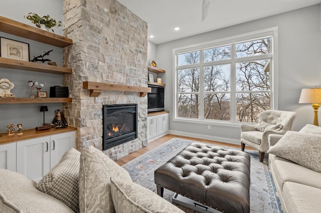 living room featuring light wood-type flooring and a fireplace