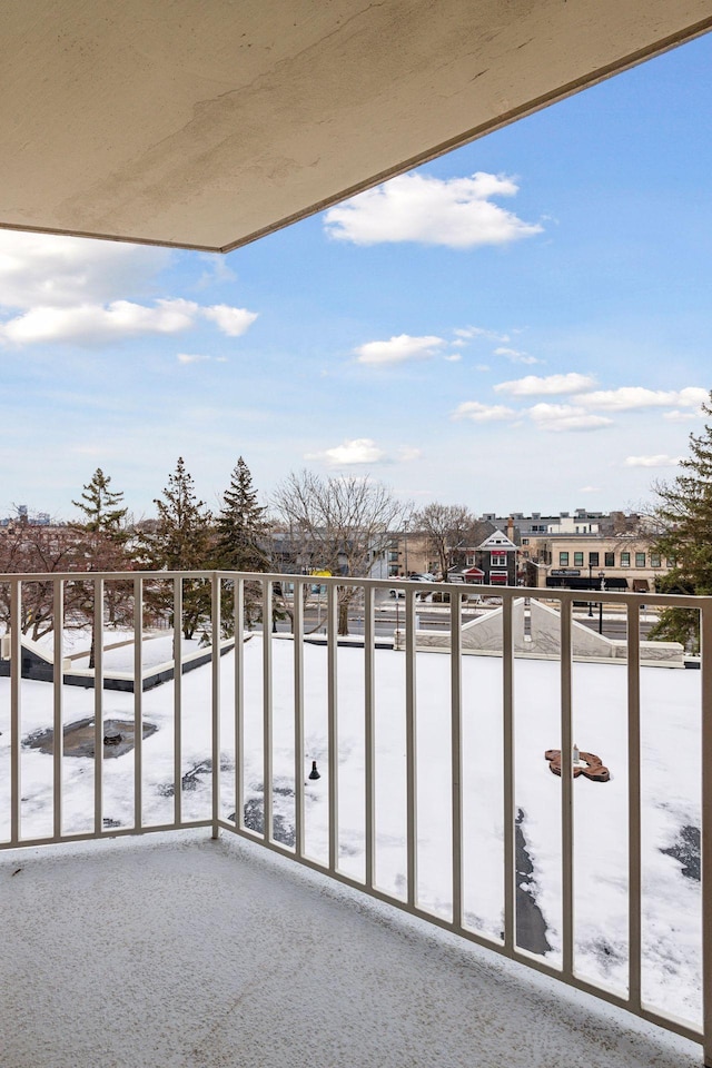 view of snow covered back of property