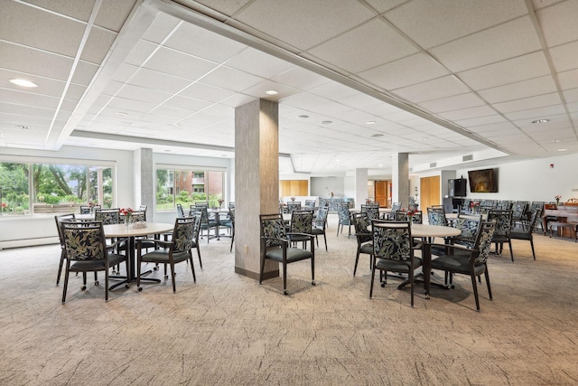 carpeted dining room featuring a paneled ceiling