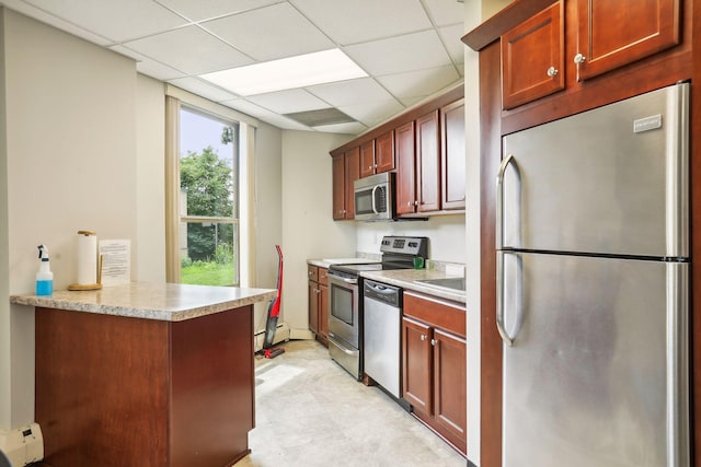 kitchen featuring appliances with stainless steel finishes, a paneled ceiling, baseboard heating, and kitchen peninsula