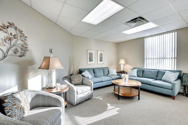 living room with a paneled ceiling and carpet