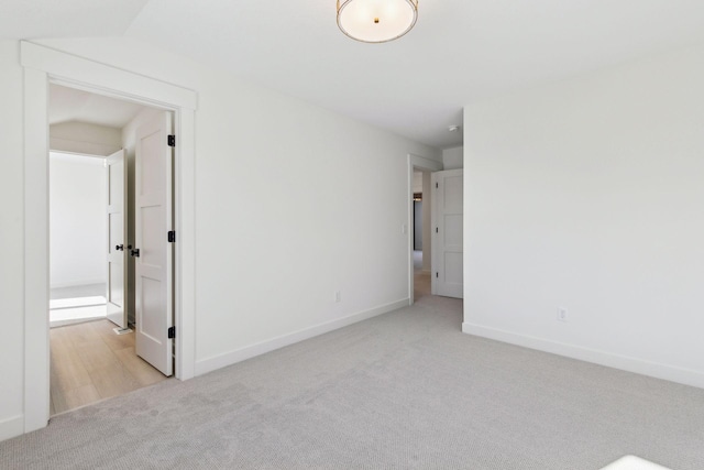 empty room with light colored carpet and baseboards