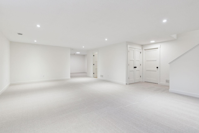 below grade area with recessed lighting, light colored carpet, and baseboards