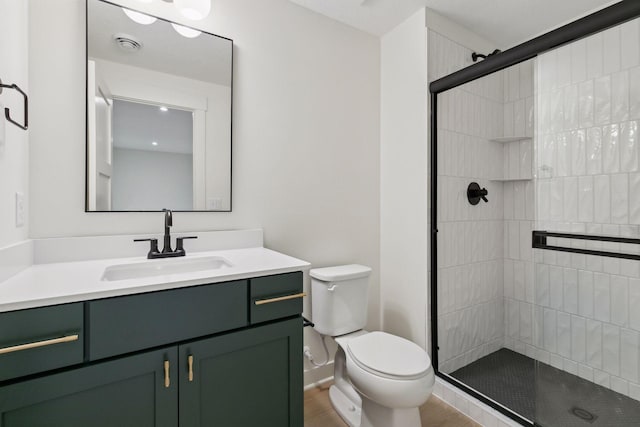 bathroom featuring a stall shower, baseboards, visible vents, toilet, and vanity