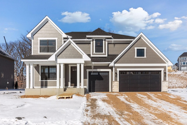 view of front of property featuring covered porch, a shingled roof, and an attached garage