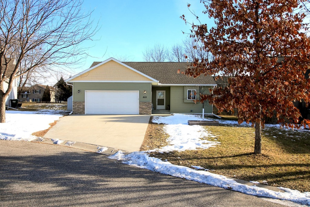 ranch-style house with a garage and a yard