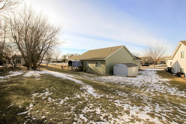 snow covered property featuring a storage shed