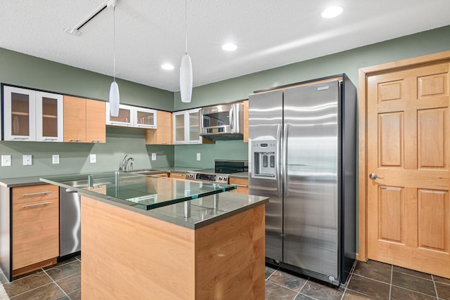 kitchen featuring a sink, decorative light fixtures, a kitchen island, appliances with stainless steel finishes, and glass insert cabinets