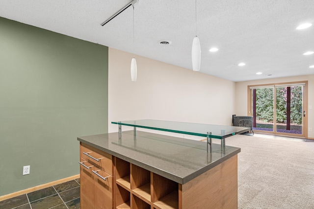 interior space featuring baseboards, dark countertops, a wood stove, and a textured ceiling