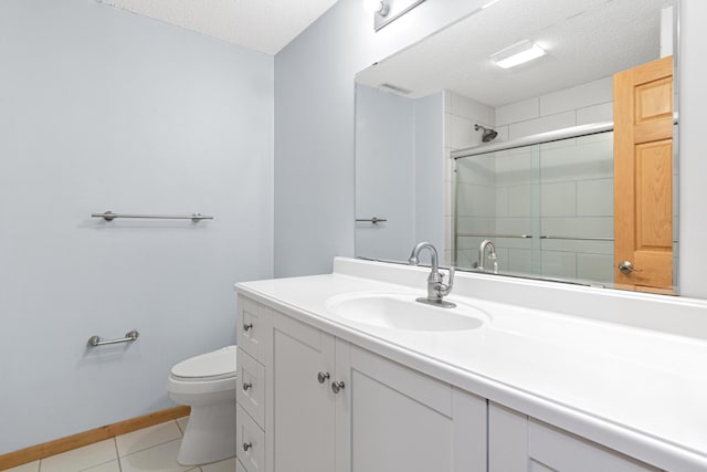 bathroom with an enclosed shower, toilet, a textured ceiling, tile patterned flooring, and vanity