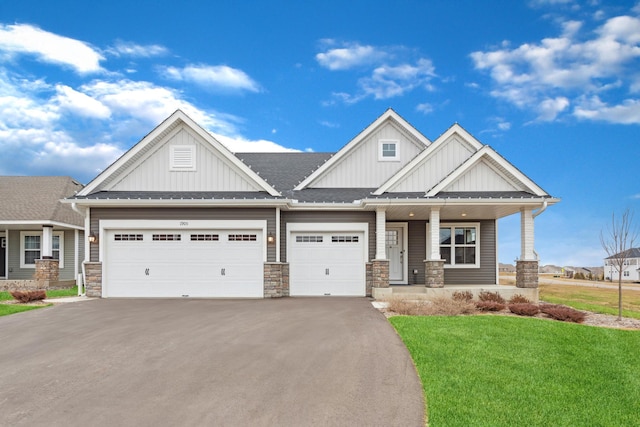 craftsman inspired home featuring a porch, a garage, and a front yard