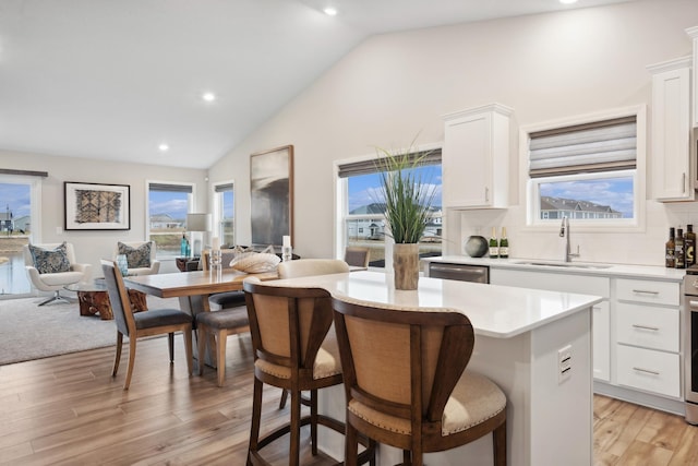 kitchen featuring a center island, backsplash, white cabinets, sink, and a breakfast bar area