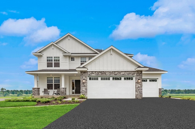 craftsman house featuring a garage, covered porch, and a front yard