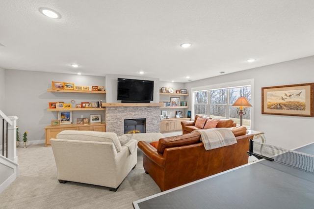 carpeted living room featuring a stone fireplace