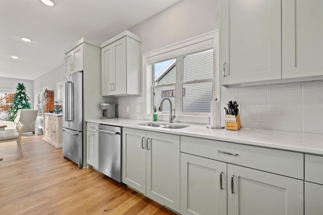 kitchen featuring backsplash, a wealth of natural light, sink, and appliances with stainless steel finishes