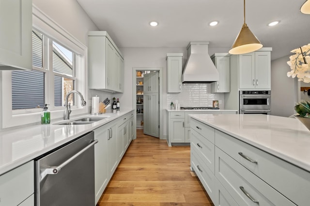 kitchen featuring white cabinetry, stainless steel dishwasher, backsplash, pendant lighting, and custom exhaust hood