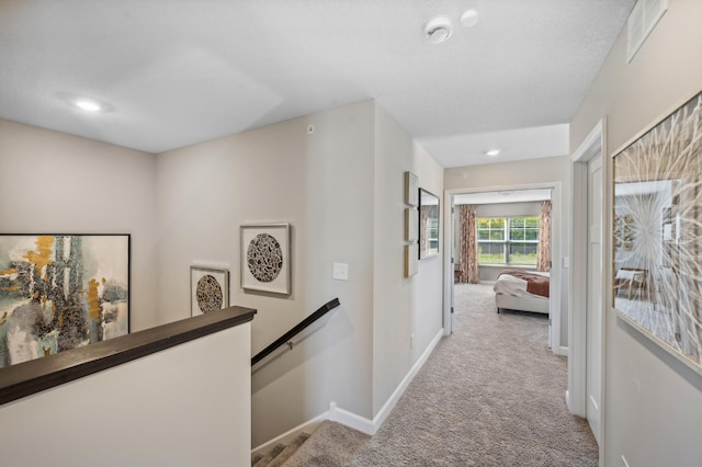 hallway featuring light colored carpet