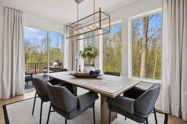 sunroom with plenty of natural light and a notable chandelier