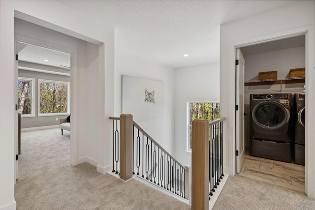 hall featuring washing machine and clothes dryer and light colored carpet