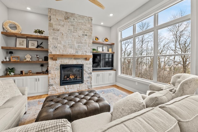 living room featuring a stone fireplace and light hardwood / wood-style floors