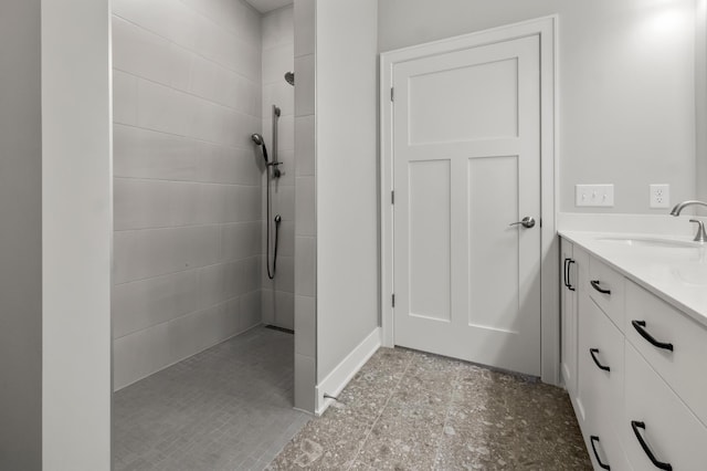 bathroom featuring a tile shower and vanity