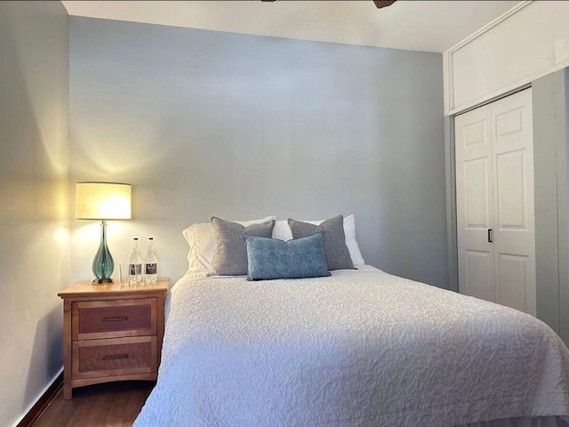 bedroom featuring ceiling fan, dark hardwood / wood-style floors, and a closet