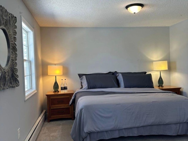 bedroom featuring multiple windows, a baseboard heating unit, a textured ceiling, and carpet flooring