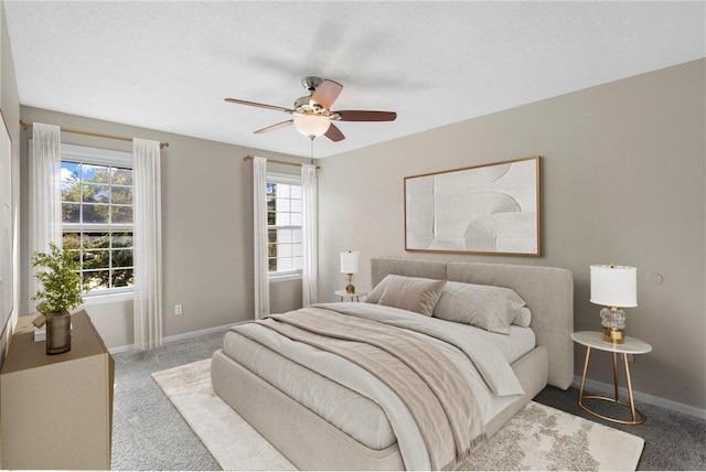 carpeted bedroom featuring a textured ceiling and ceiling fan