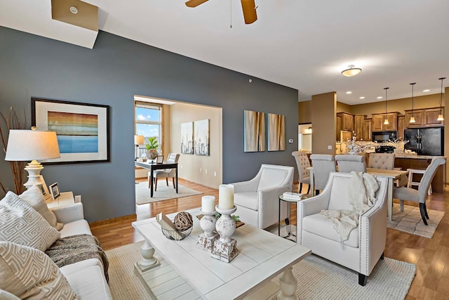 living room with ceiling fan and light wood-type flooring