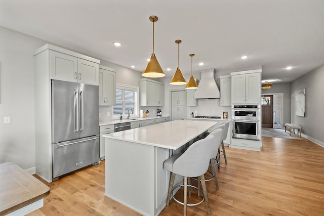 kitchen with custom exhaust hood, a center island, tasteful backsplash, decorative light fixtures, and stainless steel appliances