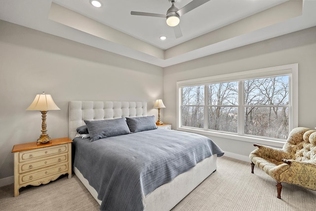 bedroom featuring a tray ceiling, ceiling fan, and light carpet