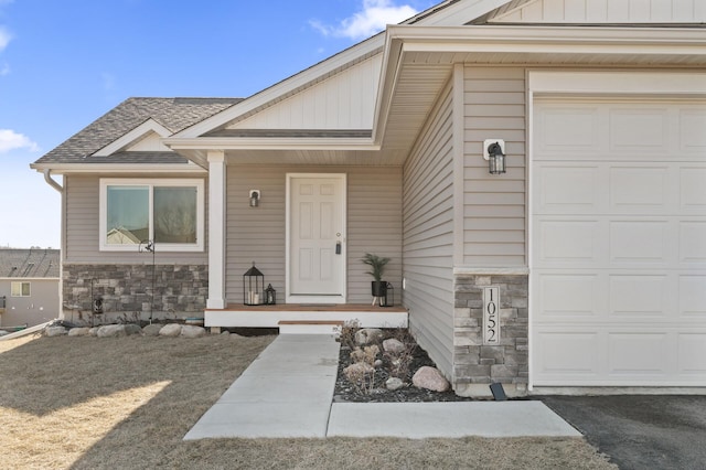 property entrance with an attached garage, stone siding, a shingled roof, and board and batten siding