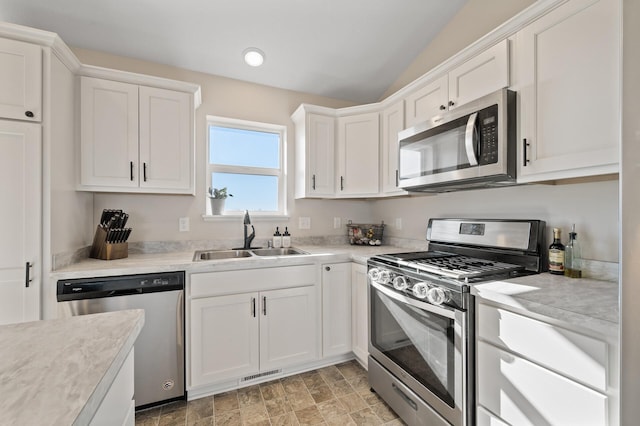 kitchen featuring stainless steel appliances, white cabinets, visible vents, and a sink