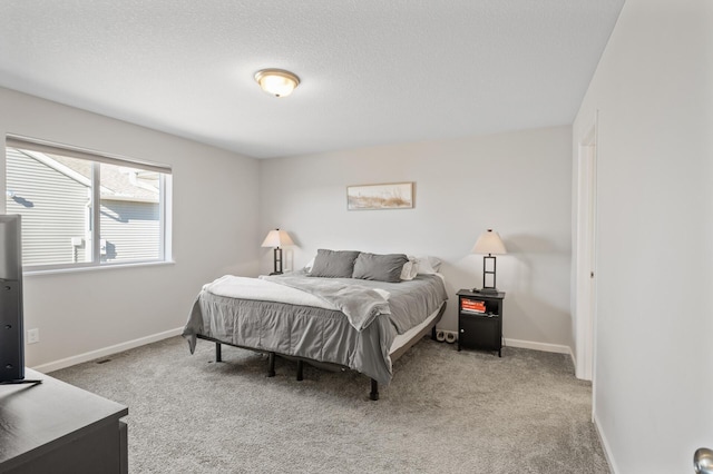 bedroom featuring carpet flooring, a textured ceiling, and baseboards