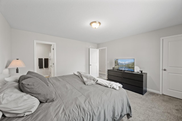 carpeted bedroom with baseboards and ensuite bathroom