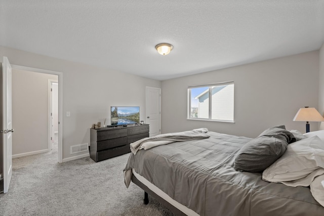 carpeted bedroom featuring baseboards, visible vents, and a textured ceiling