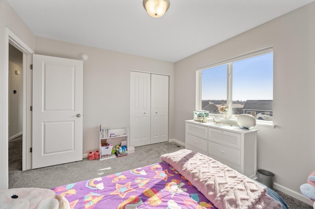 carpeted bedroom featuring baseboards and a closet