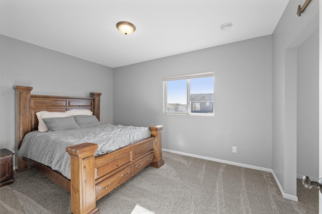 bedroom featuring baseboards and light colored carpet