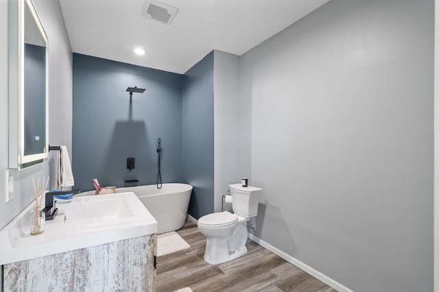 bathroom with visible vents, baseboards, toilet, wood finished floors, and a freestanding bath