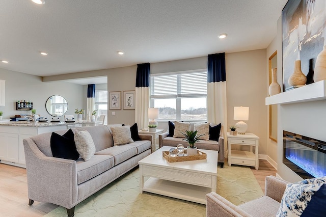 living room featuring light wood-type flooring and a textured ceiling