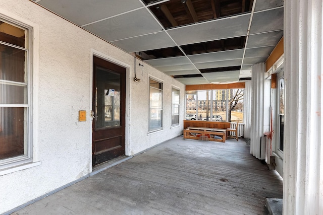 unfurnished sunroom featuring a drop ceiling