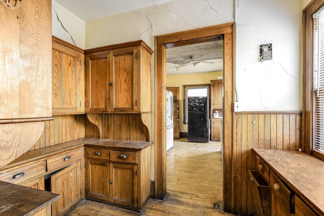 kitchen with wood walls and light wood-type flooring